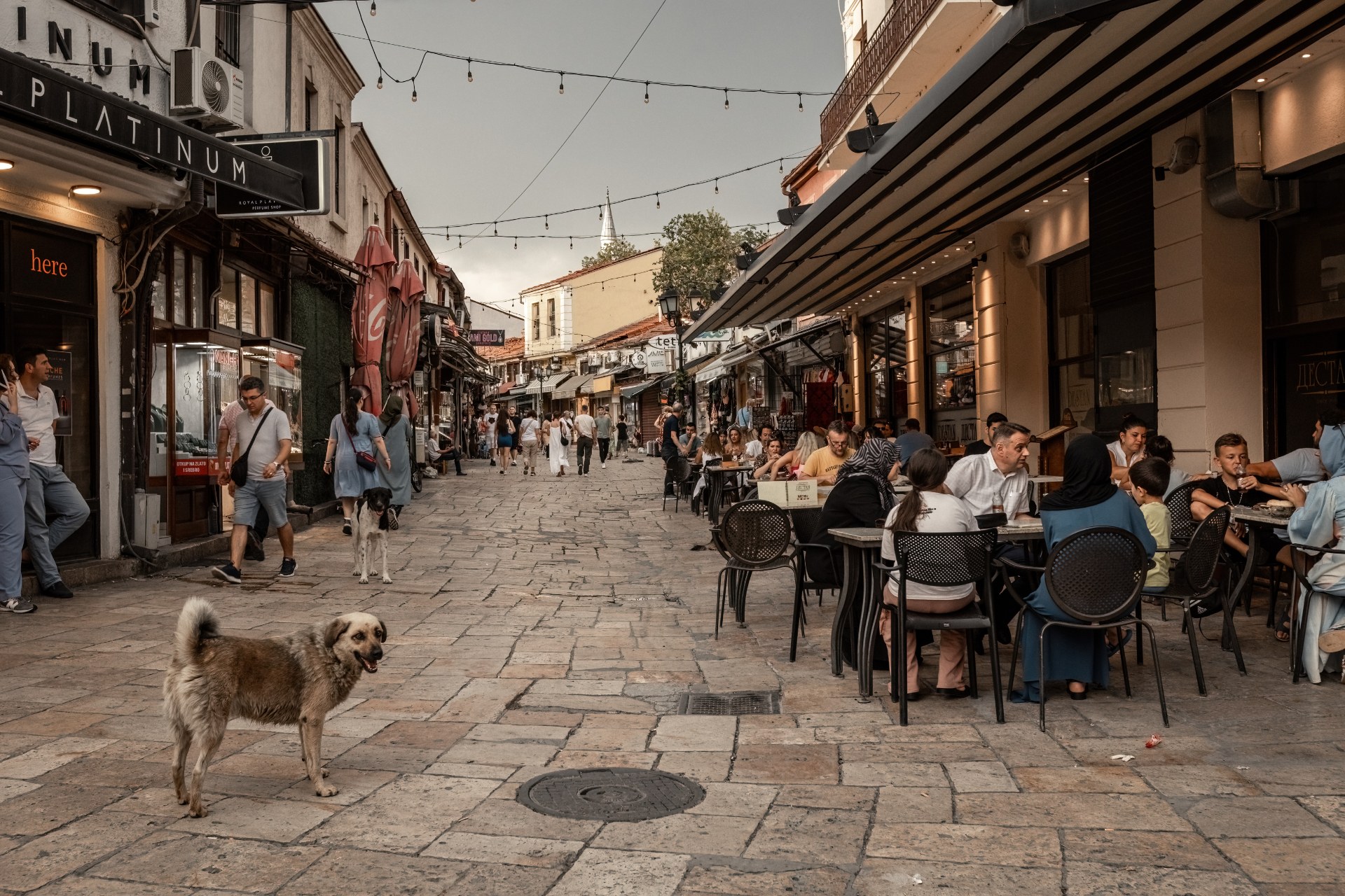 Üsküp’ün eski çarşısında dar bir sokaktaki kafelerde oturan insanlar